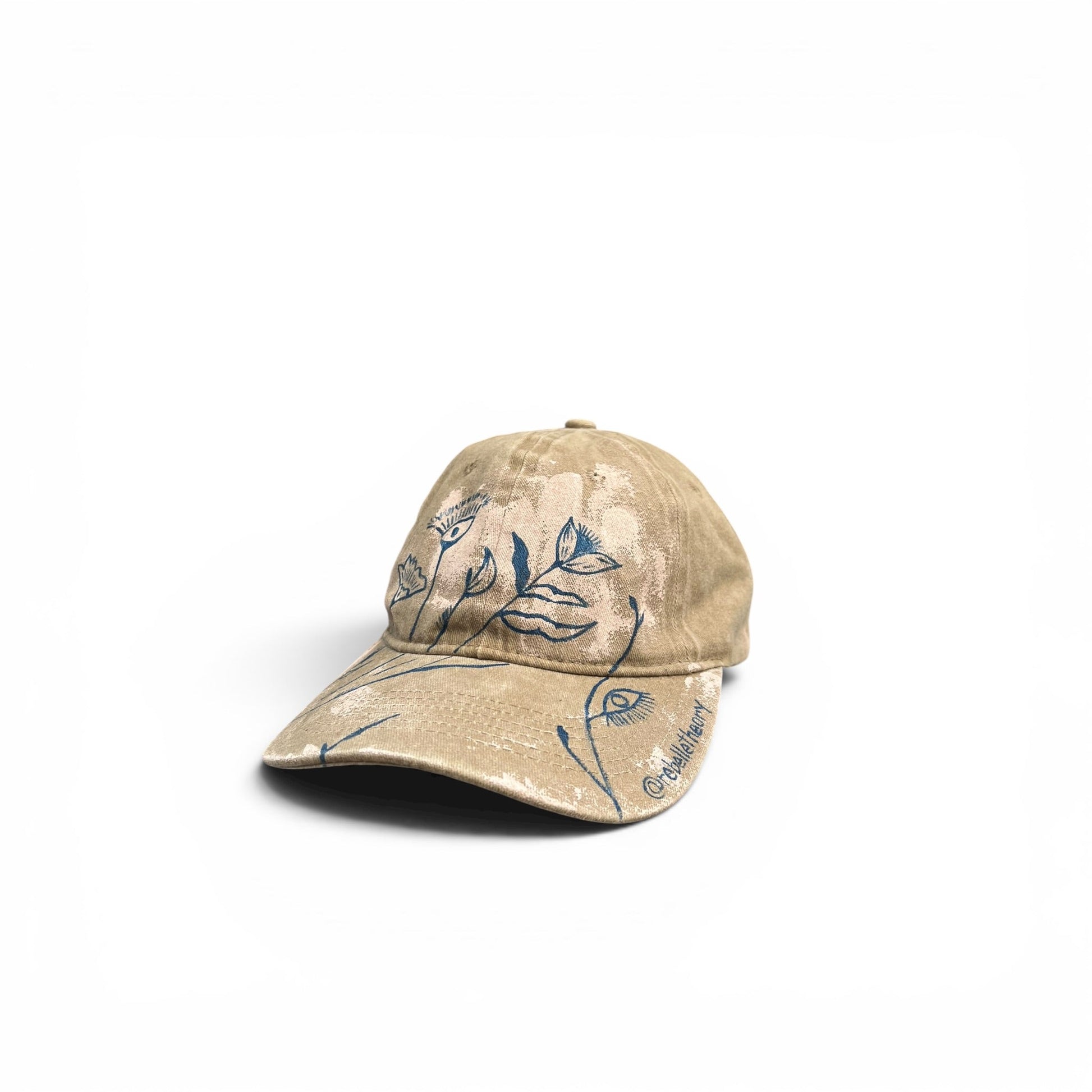 Beige cap with blue floral designs on a white background